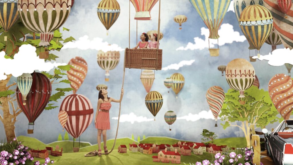 girl hanging unto hot air balloon for cirkus commercial